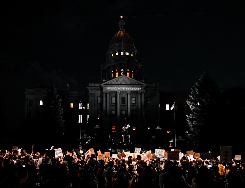 people in front of white building during nighttime