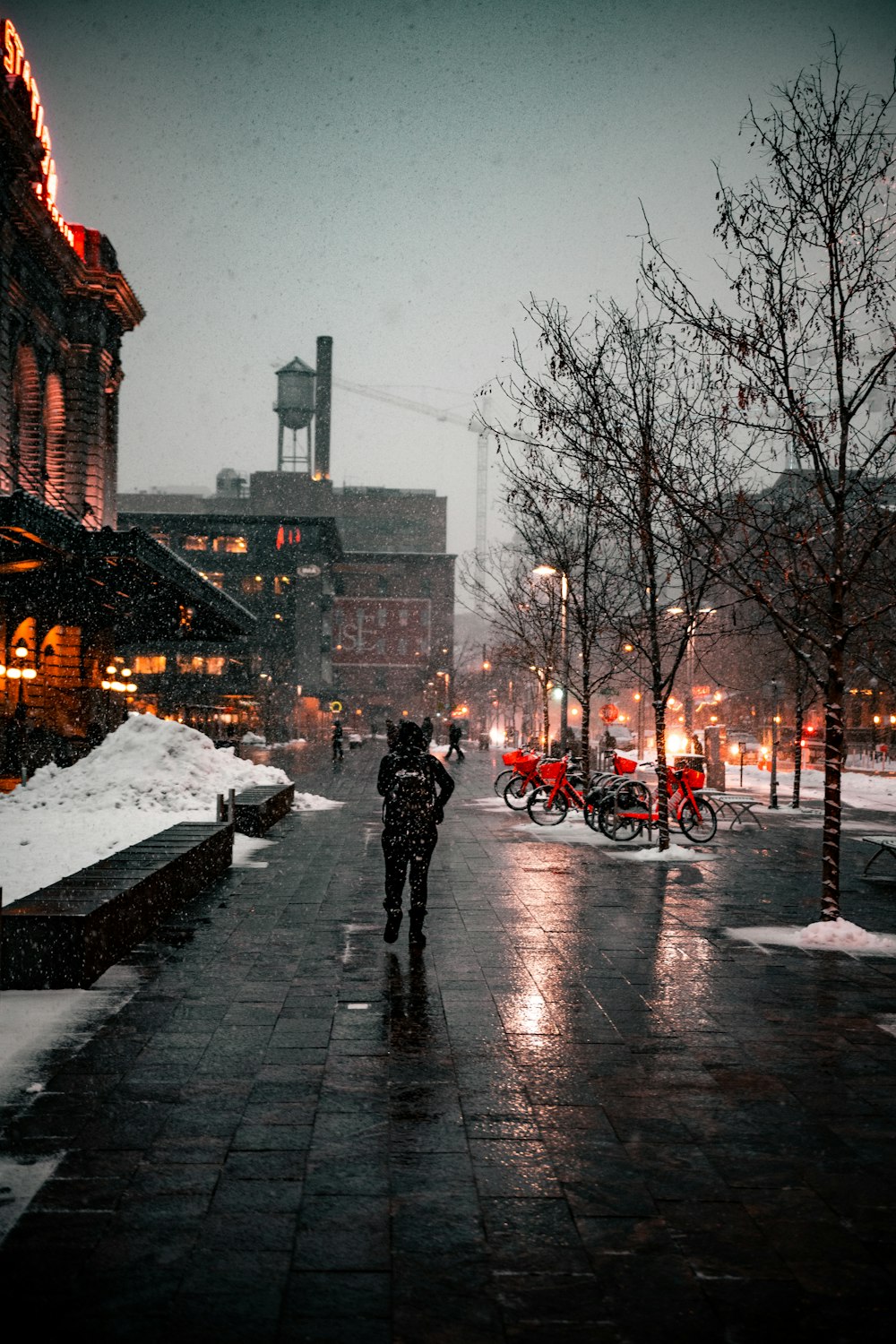 person in black coat standing on snow covered road during daytime