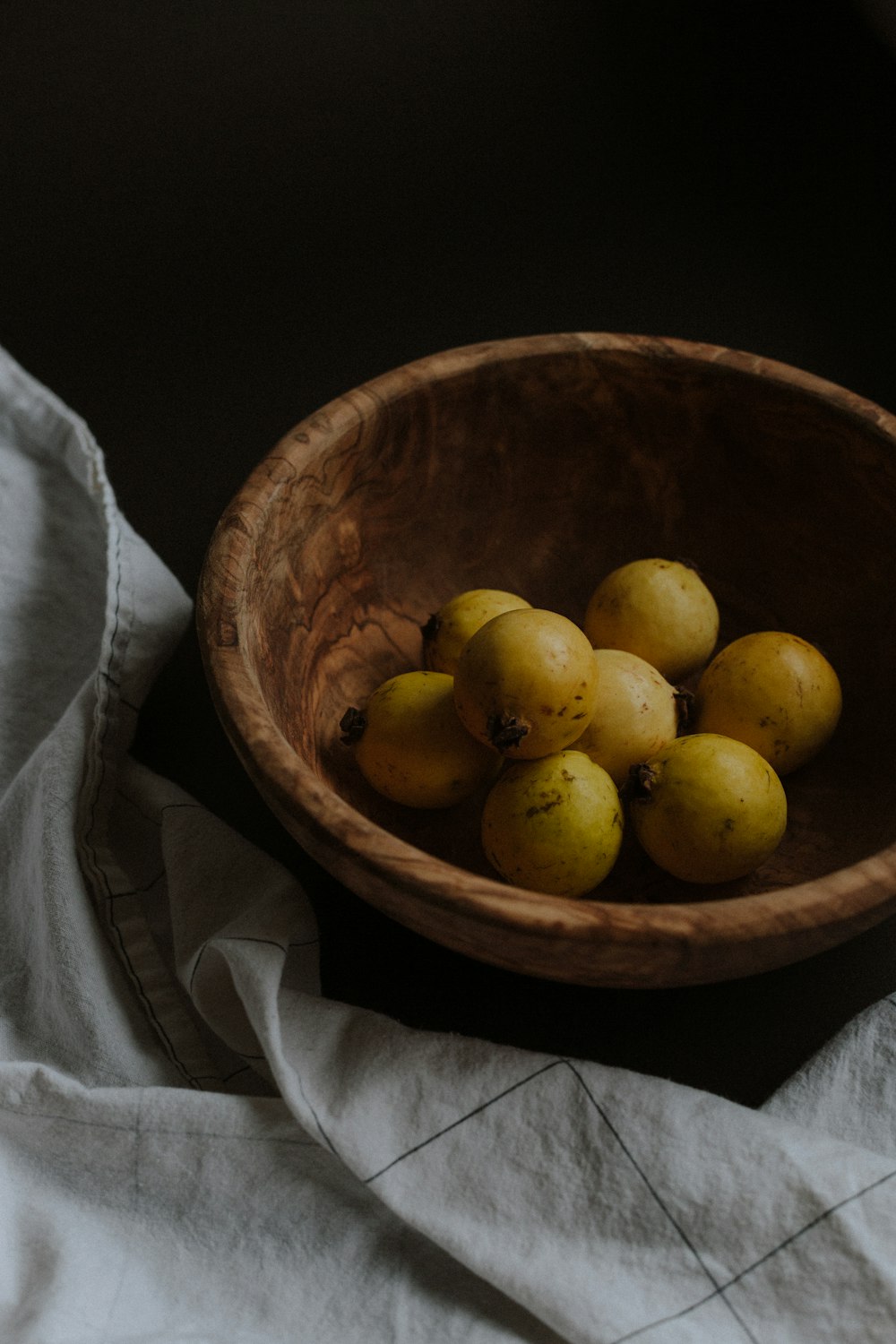 fruits ronds jaunes dans un bol en bois brun