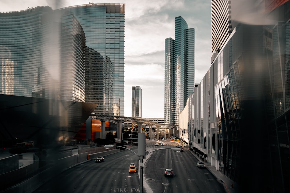 cars on road between high rise buildings during daytime