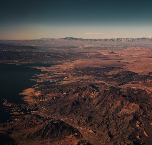 brown mountains near body of water during daytime