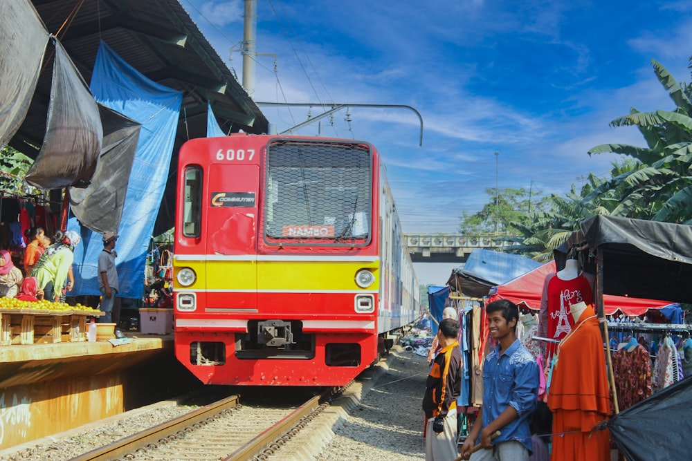 people standing beside red train during daytime