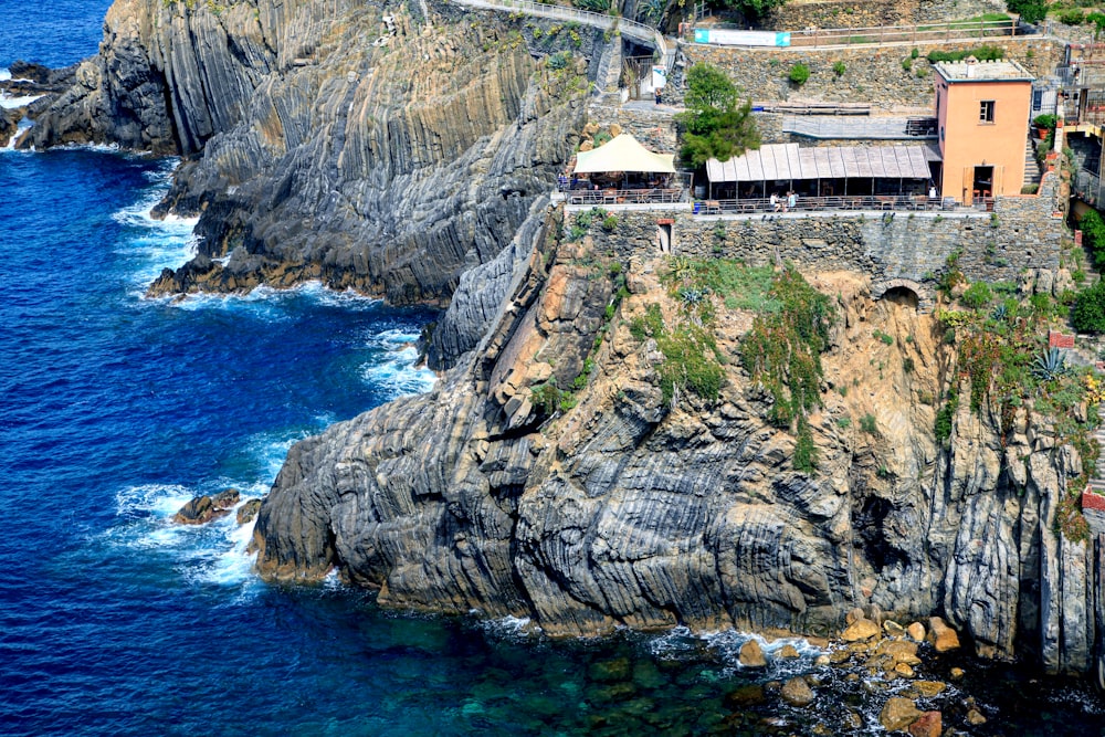 white concrete building on cliff near body of water during daytime