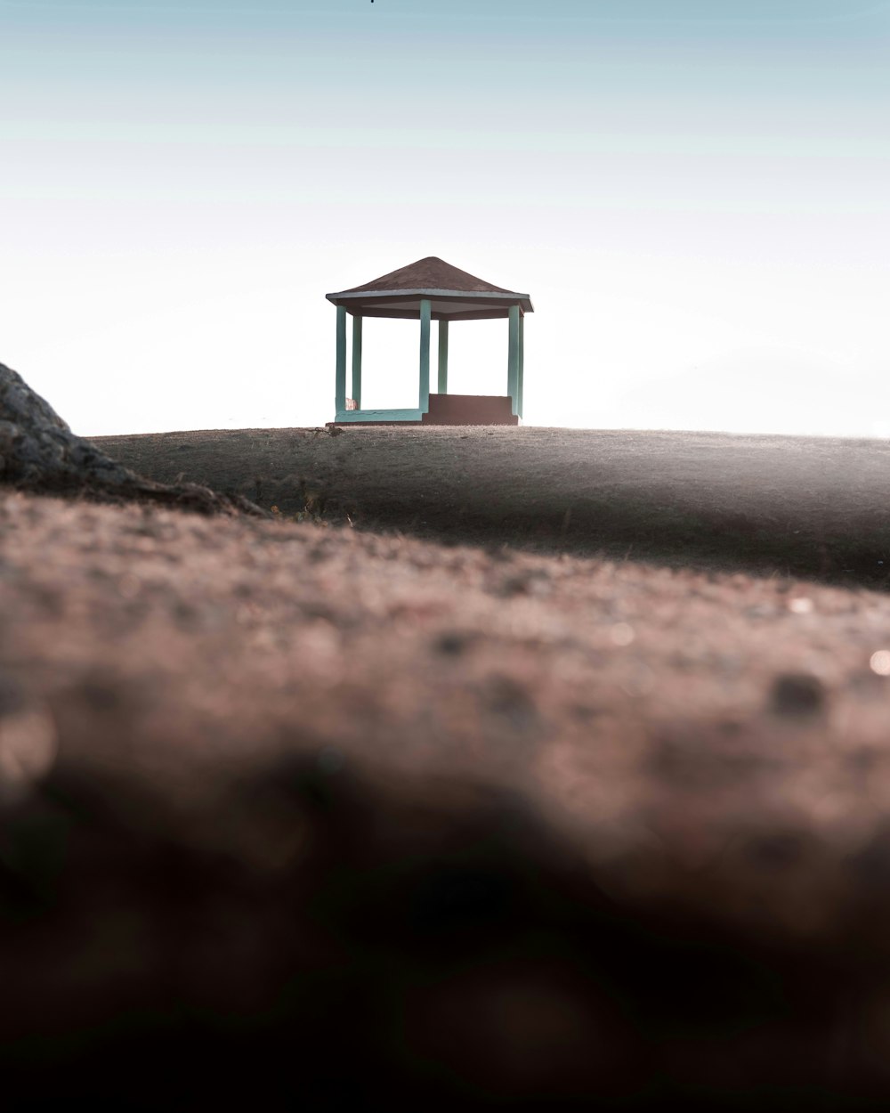 white wooden gazebo on gray sand during daytime