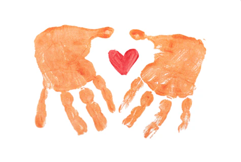 Two orange handprints facing each other with a small red heart between them