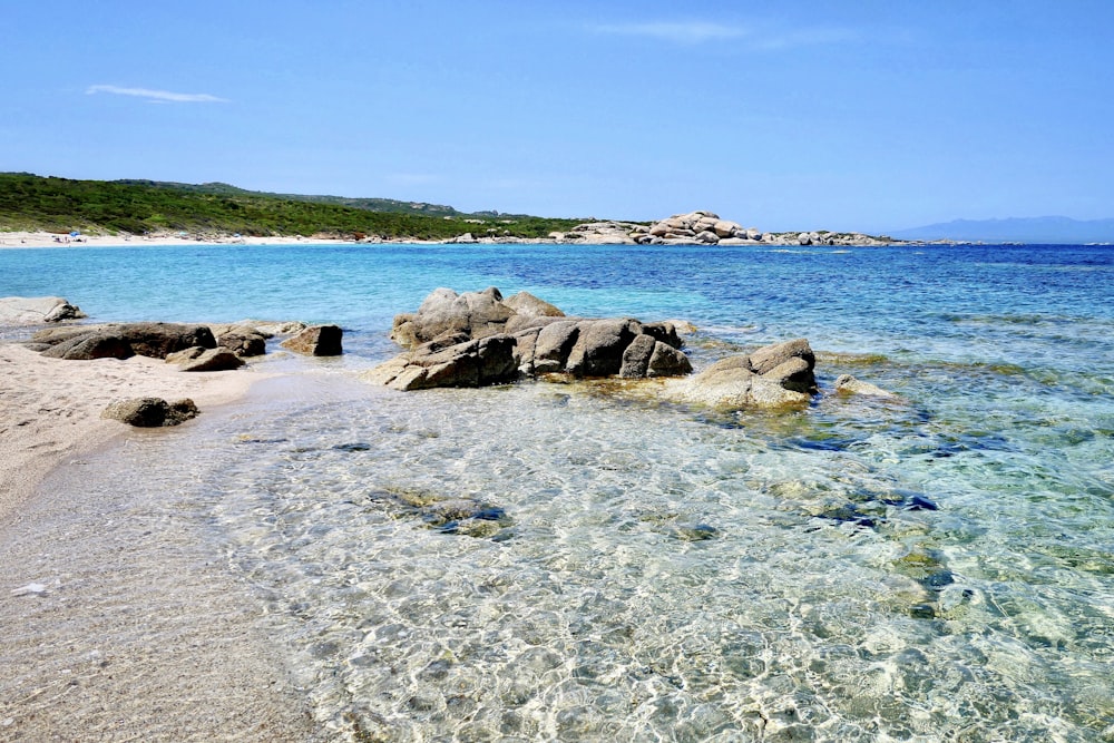 brown rocks on blue sea under blue sky during daytime