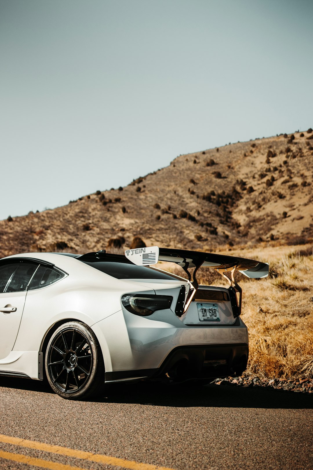 white porsche 911 on brown field during daytime