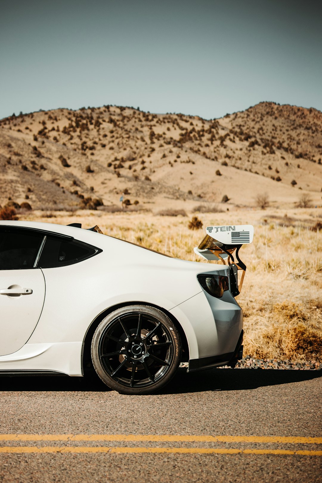 white porsche 911 on brown field during daytime