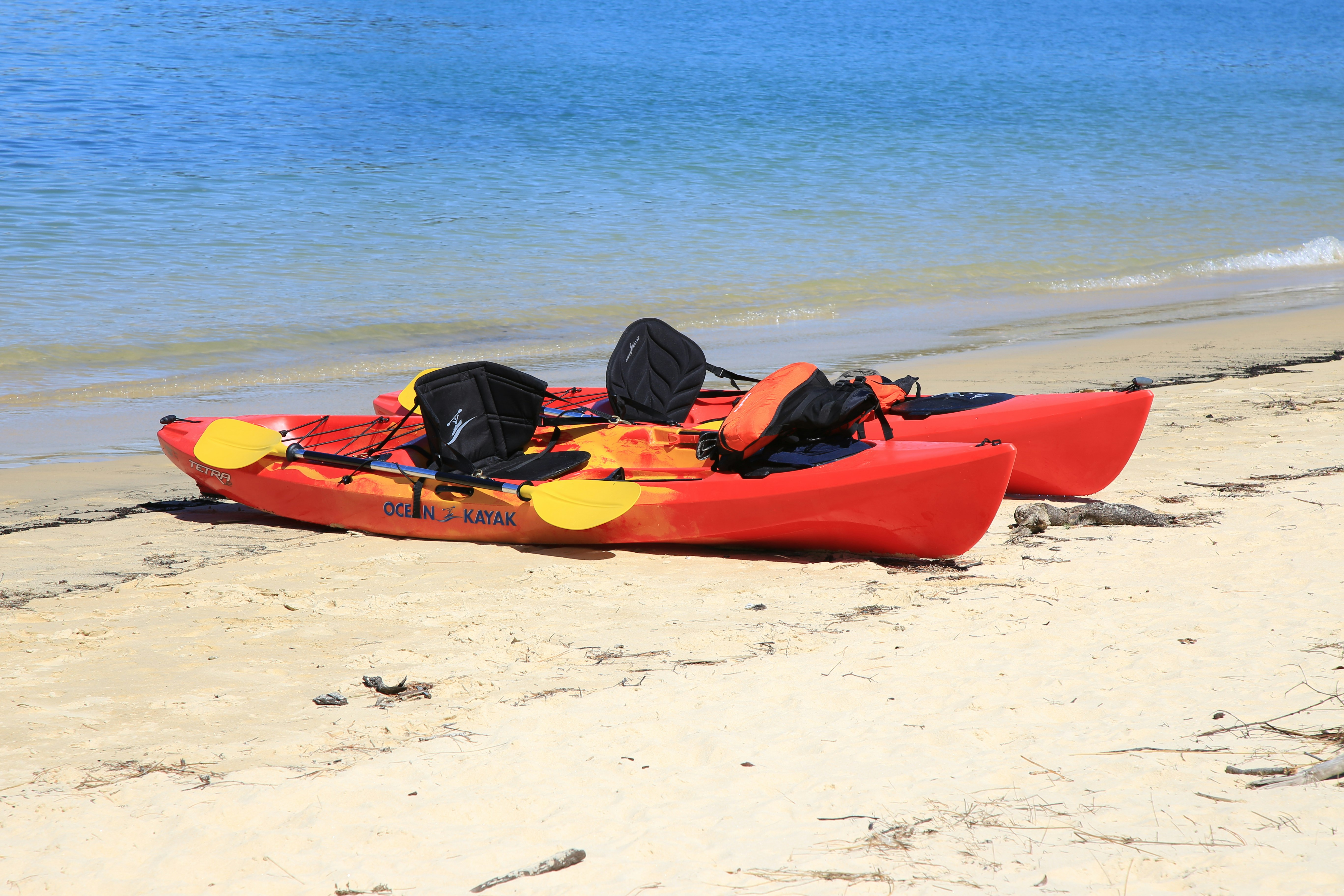 red kayak on white sand beach during daytime