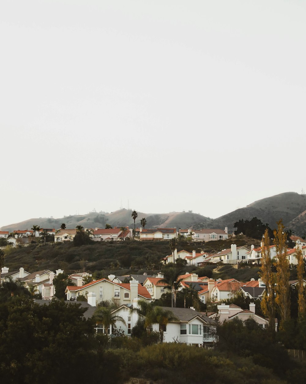 white and brown concrete houses near mountain during daytime