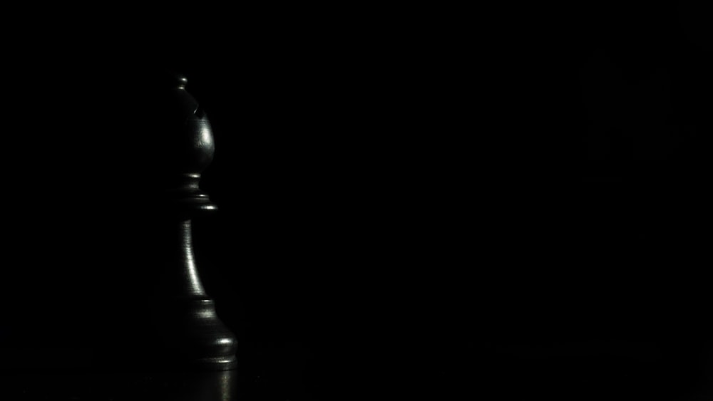 black wooden chess piece on black surface