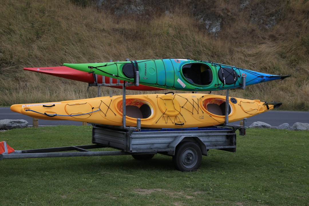 yellow and green wooden boat on gray asphalt road during daytime