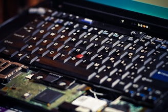 Close-up of a Dell laptop keyboard being repaired with precision tools.