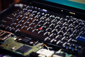 Laptop keyboard with visible liquid damage under inspection