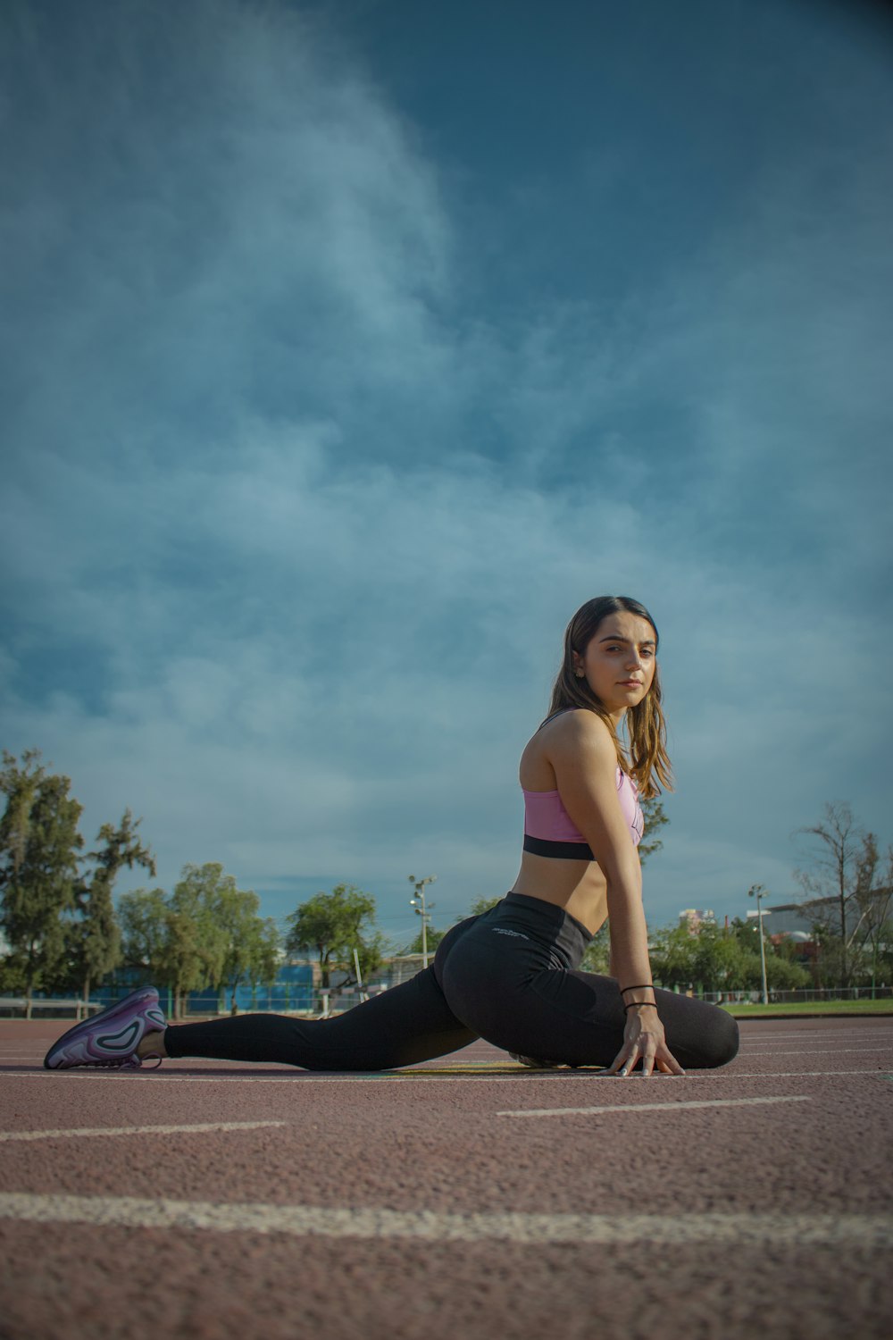 woman in black tank top and black leggings sitting on brown wooden bench during daytime