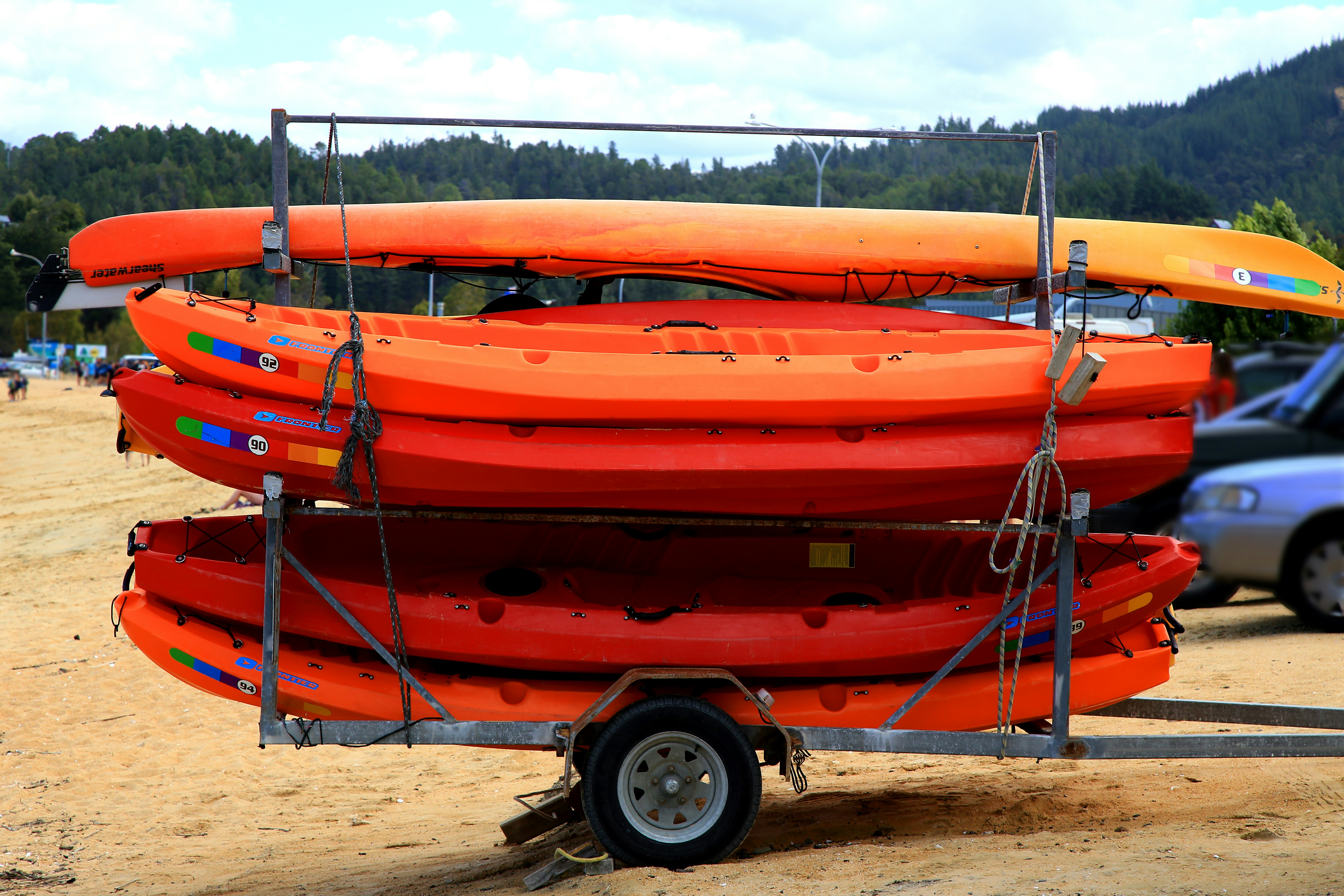 orange and black kayak on brown sand during daytime