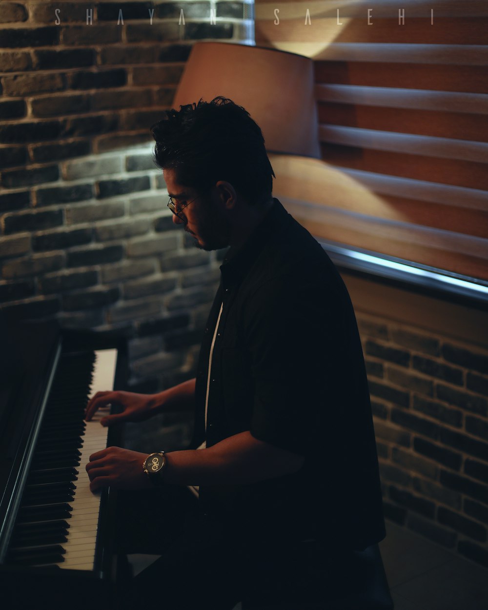 man in black coat playing piano