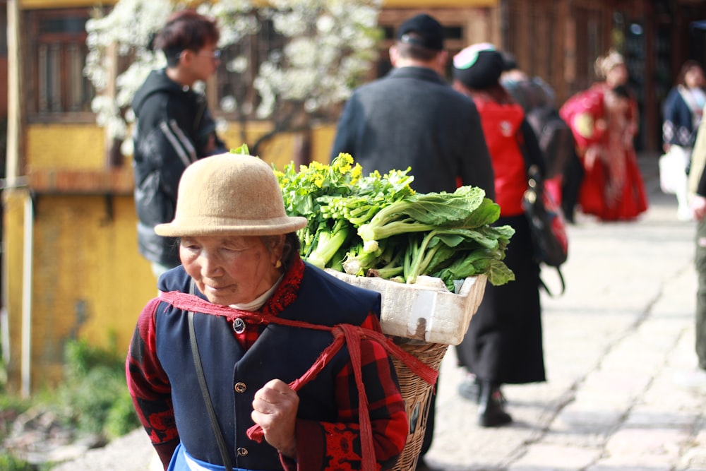 man in red and blue jacket holding green vegetable