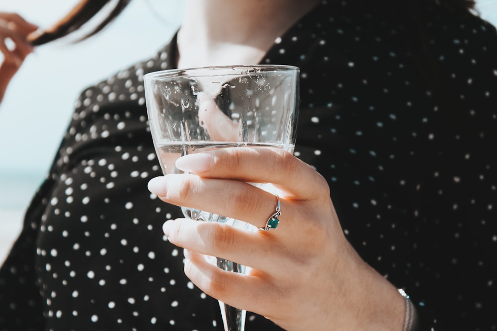 person holding clear drinking glass