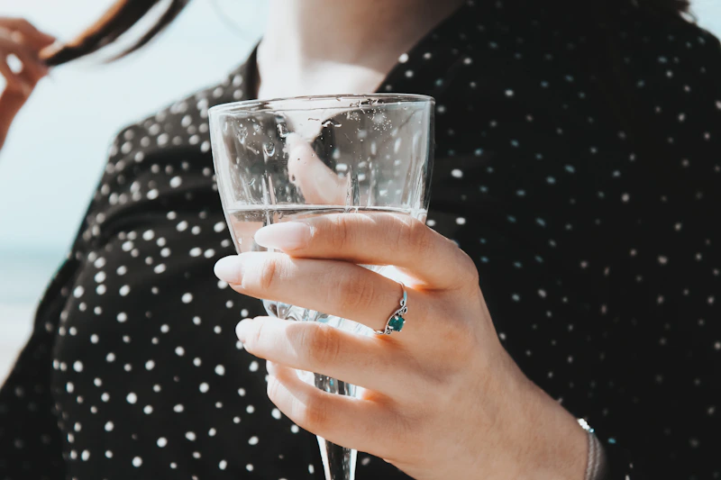 hand holding a clear drink glass