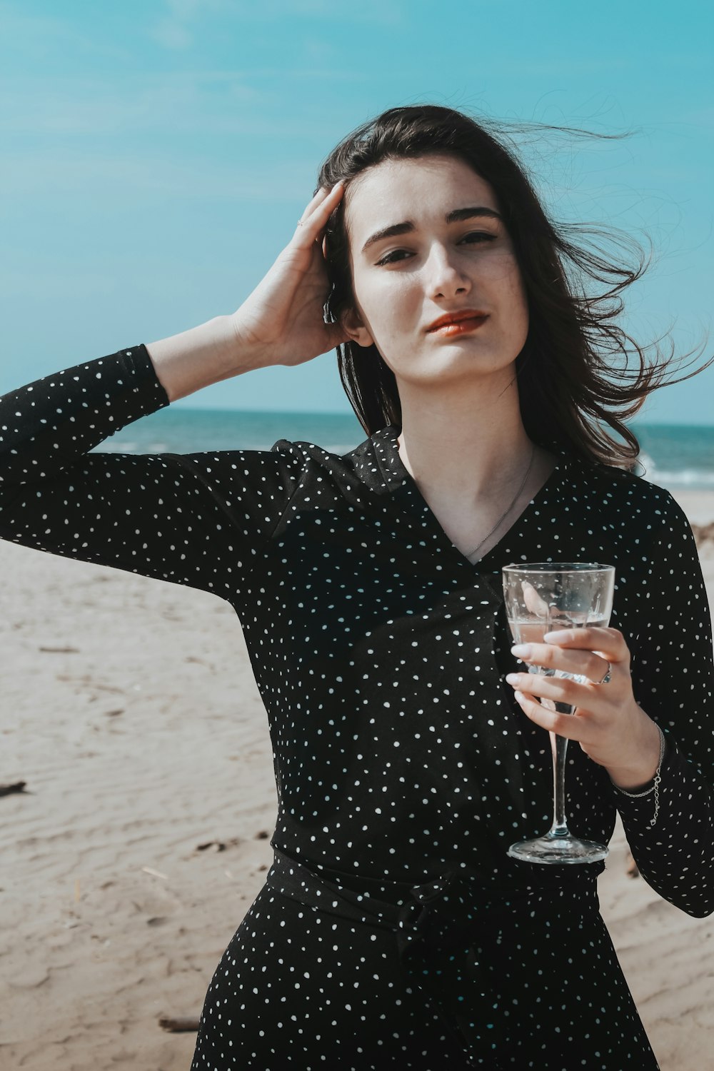 woman in black v neck long sleeve shirt holding clear wine glass