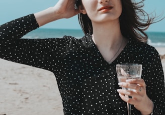 woman in black v neck long sleeve shirt holding clear wine glass