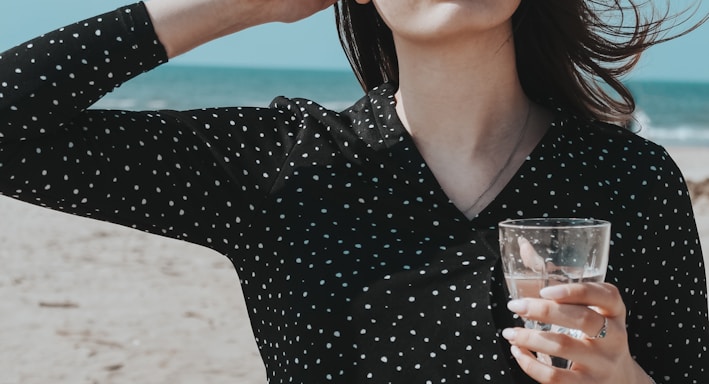 woman in black v neck long sleeve shirt holding clear wine glass
