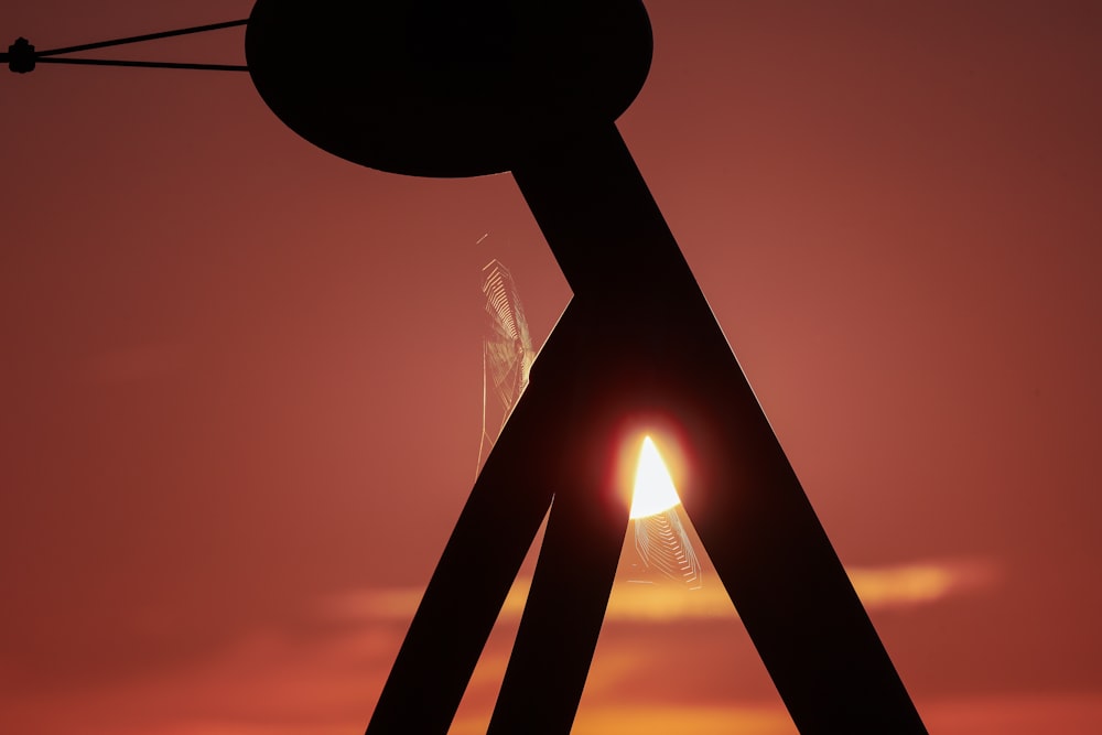 silhouette of a man standing on a ladder during sunset