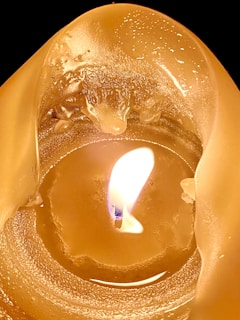 Close-up of a Pyre Candle with melting wax forming delicate patterns in warm amber hues.