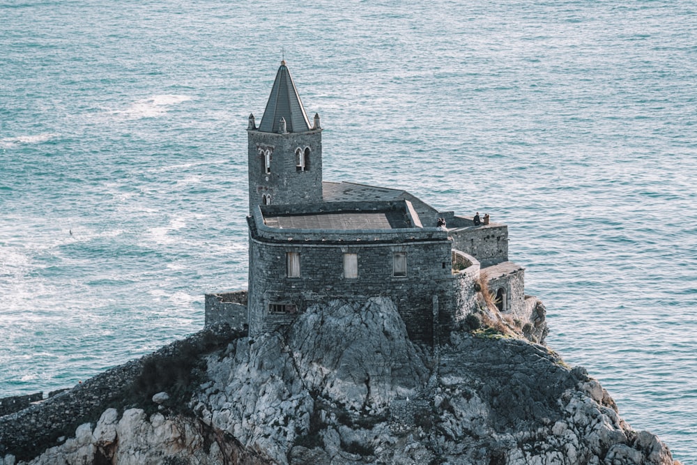 gray concrete building on cliff by the sea during daytime