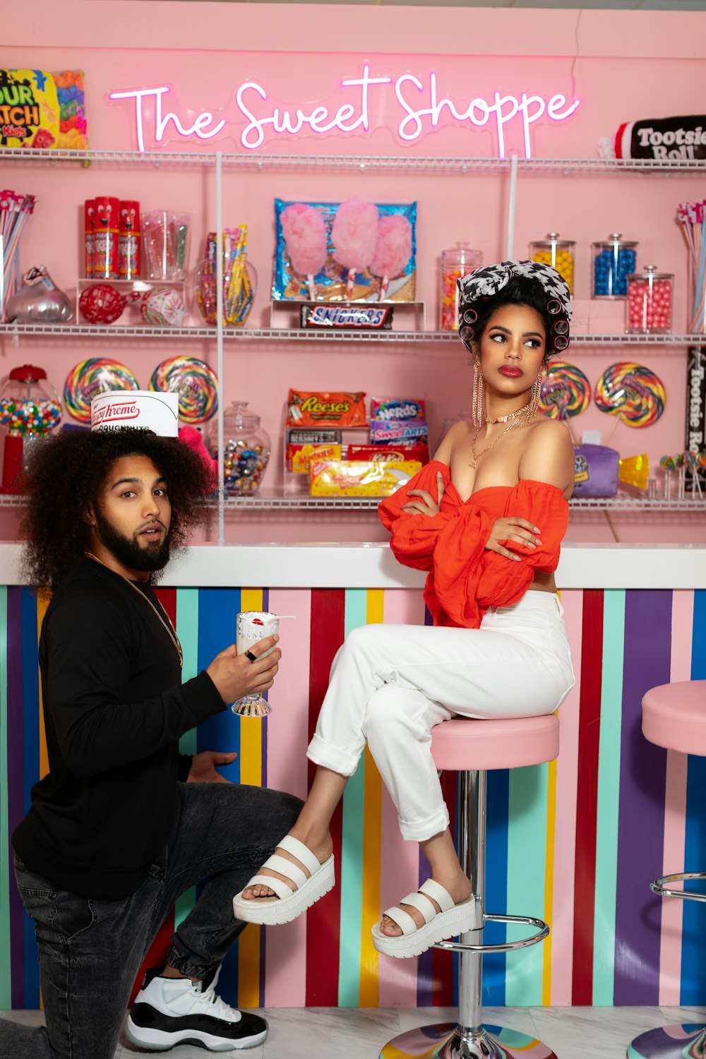 woman in blue long sleeve shirt and pink pants sitting on pink and white wooden table