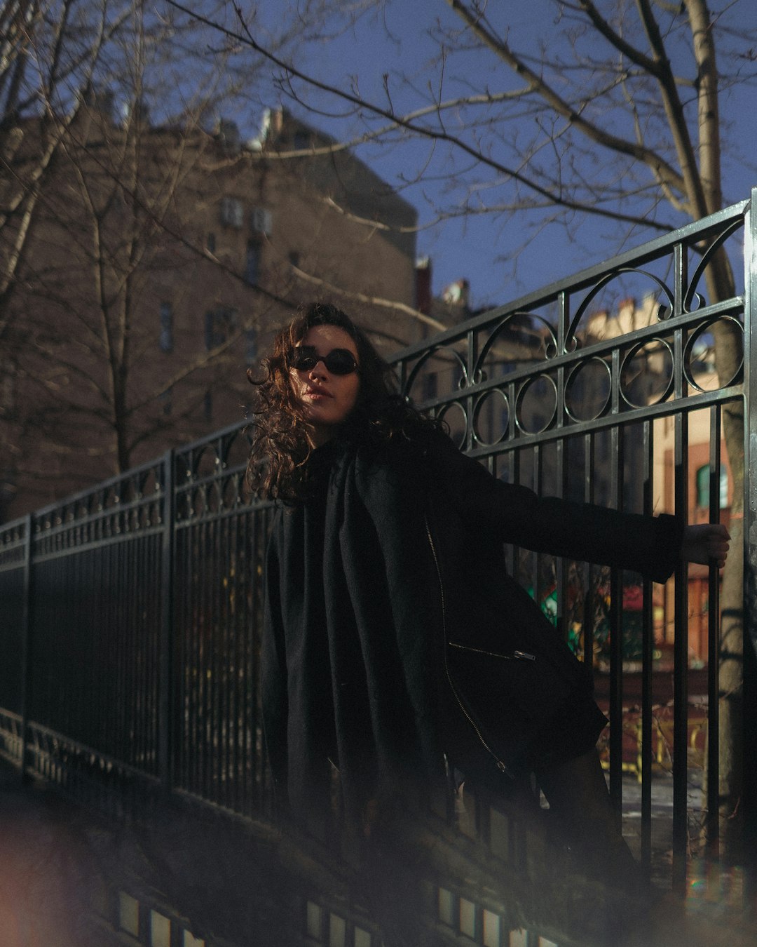 woman in black coat standing on bridge