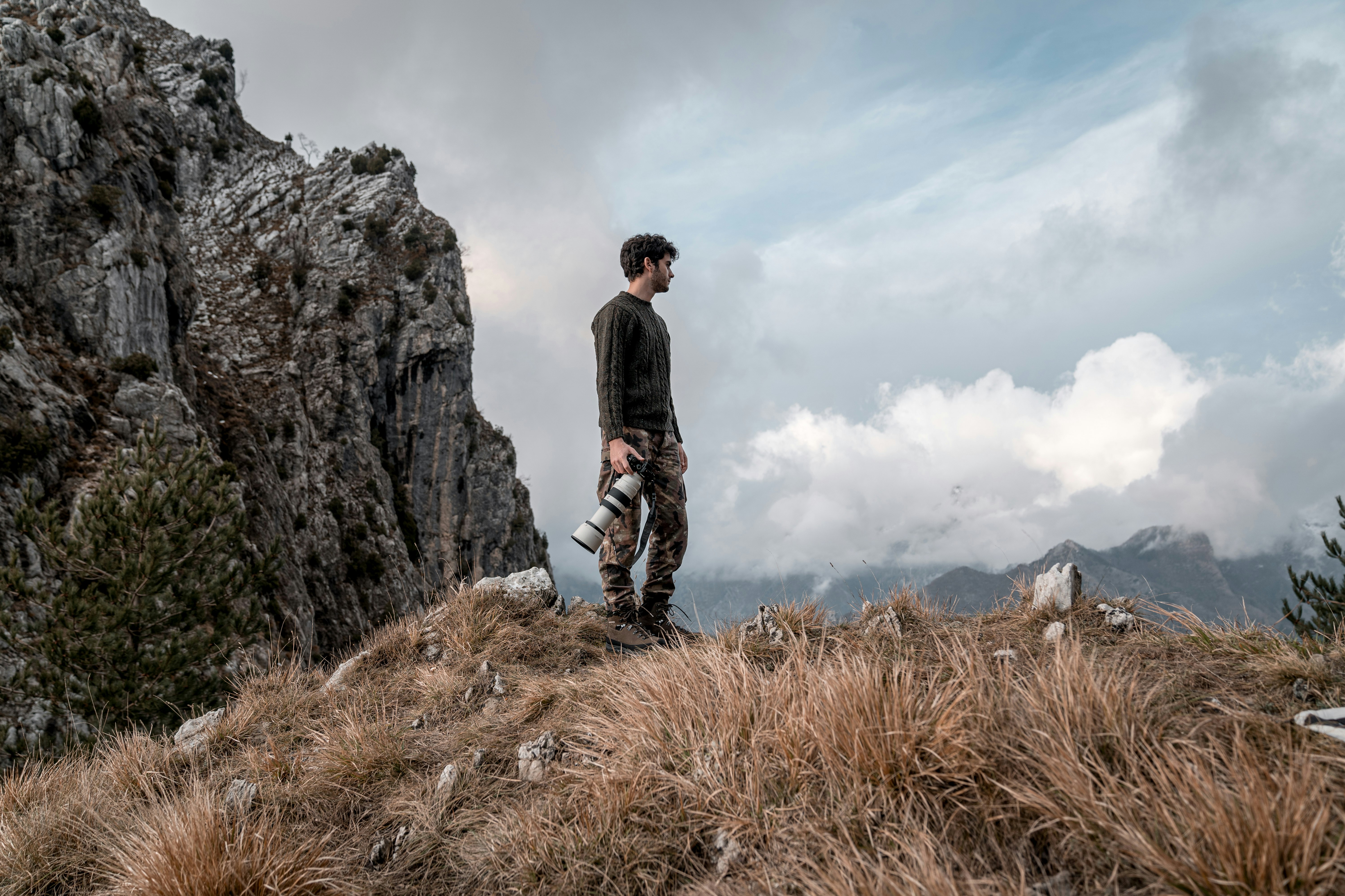 man in black jacket standing on brown grass field during daytime