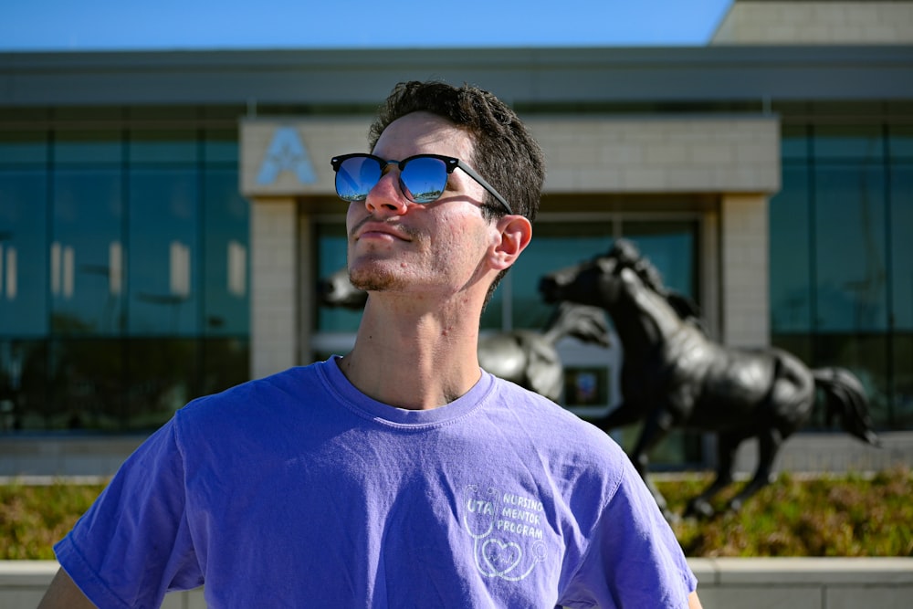 man in blue crew neck shirt wearing blue sunglasses