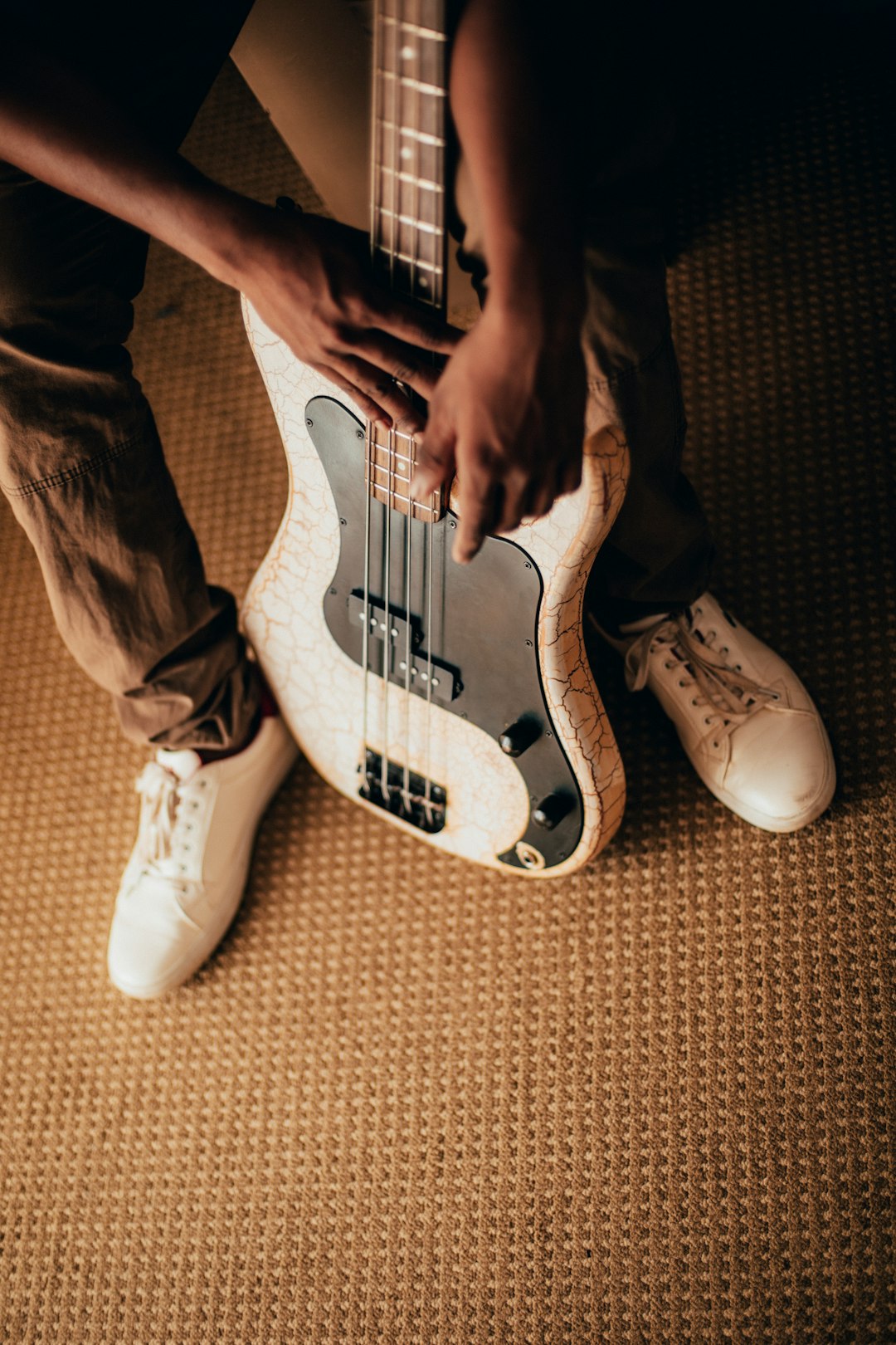 person holding white and black stratocaster electric guitar