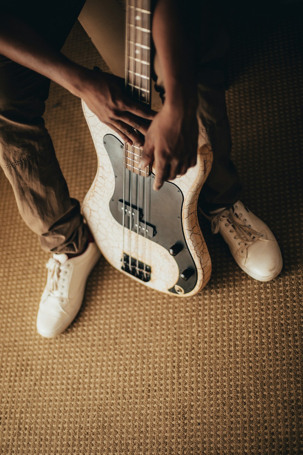 person holding white and black stratocaster electric guitar
