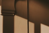 Abstract shadows cast on a textured wall in natural light.