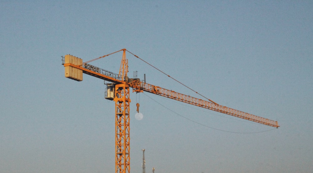 yellow crane under blue sky during daytime