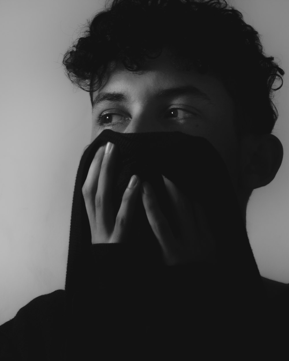 grayscale photo of woman covering her face
