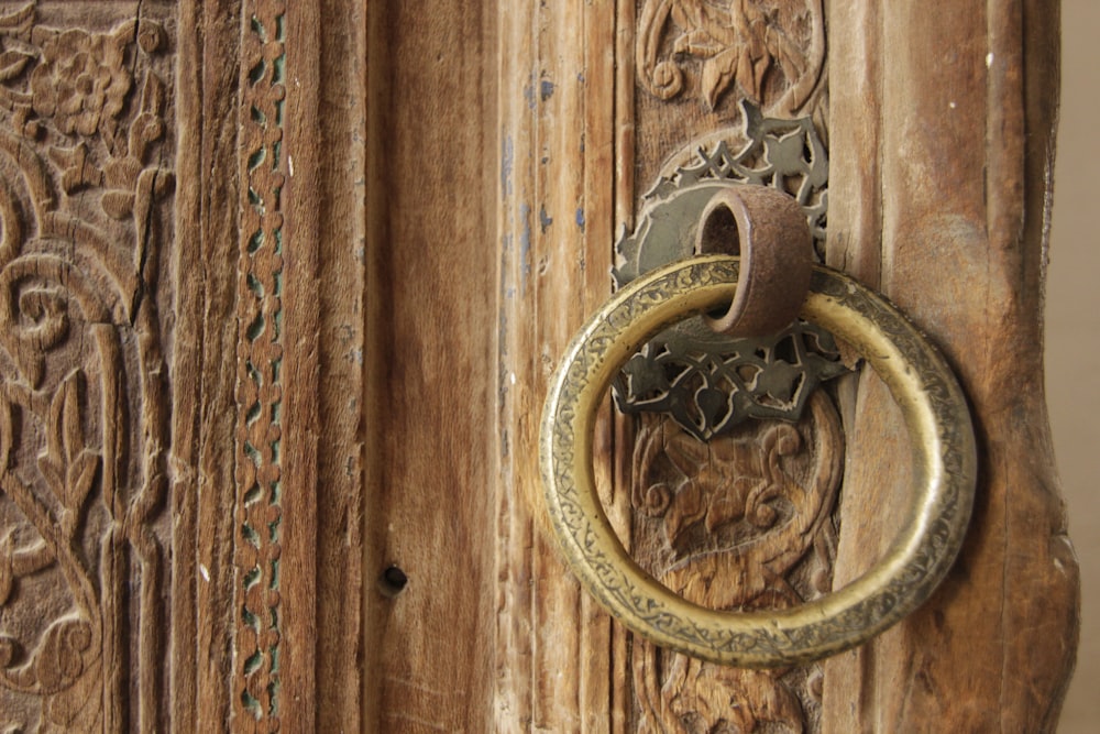 gold door handle on brown wooden door