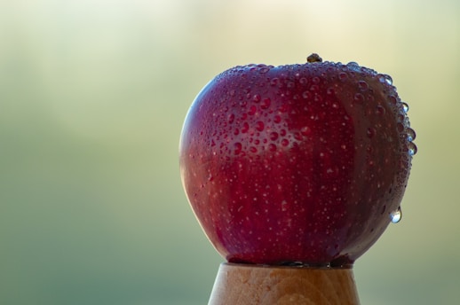 Close-up of a fresh green apple resting on a wooden table, symbolizing natural blood sugar balance.