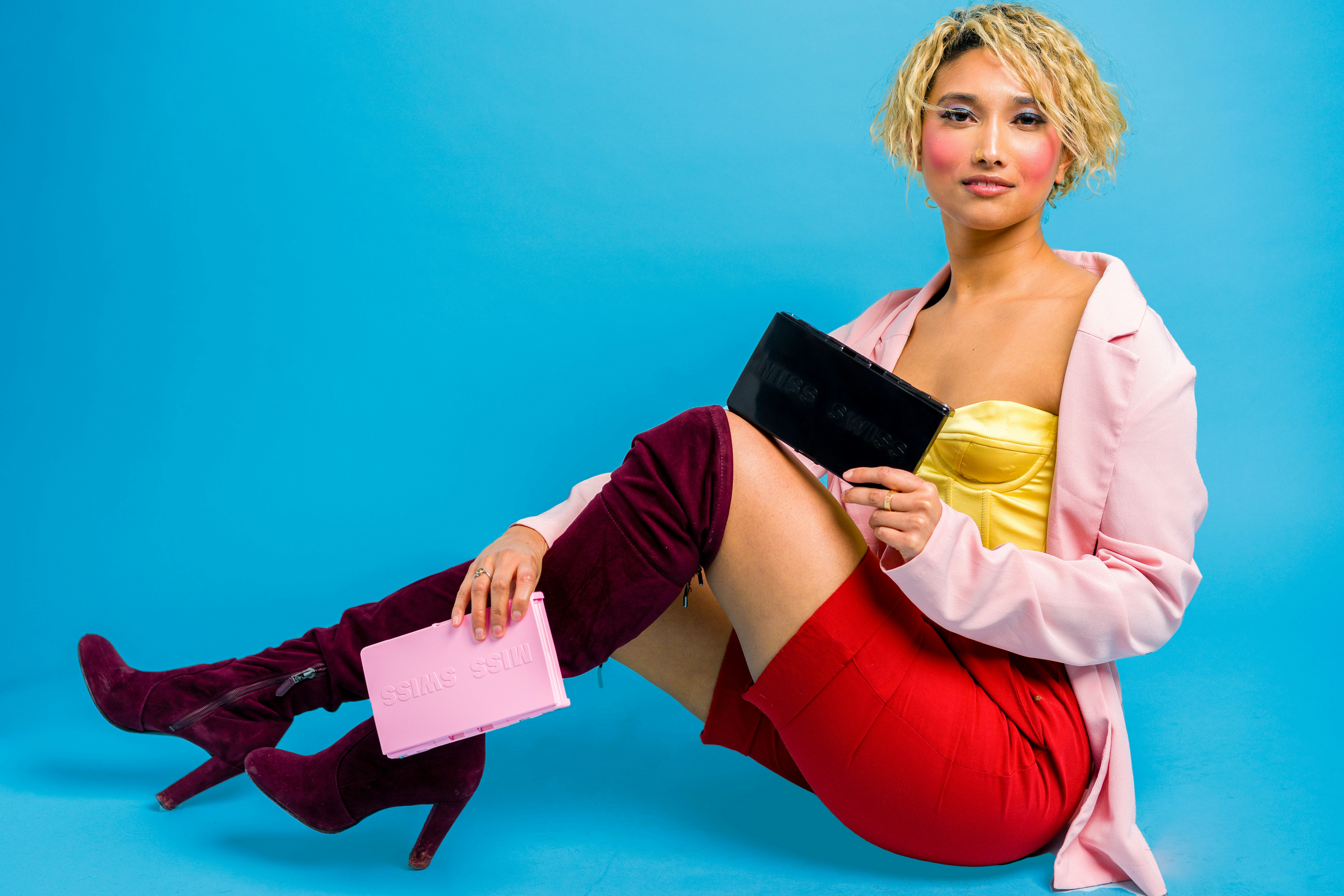 woman in yellow long sleeve shirt holding white card, MISS SWISS helps makeup wearers with glamour on the go no matter where their travels take them. The MISS SWISS makeup case was created from a personal purse catastrophe. It helps you apply your makeup easily on the go, prevent your makeup from spilling, and to prevent your makeup from getting lost. It is the perfect something blue for your wedding day. Touching up your makeup after your ceremony or between photos is a breeze.