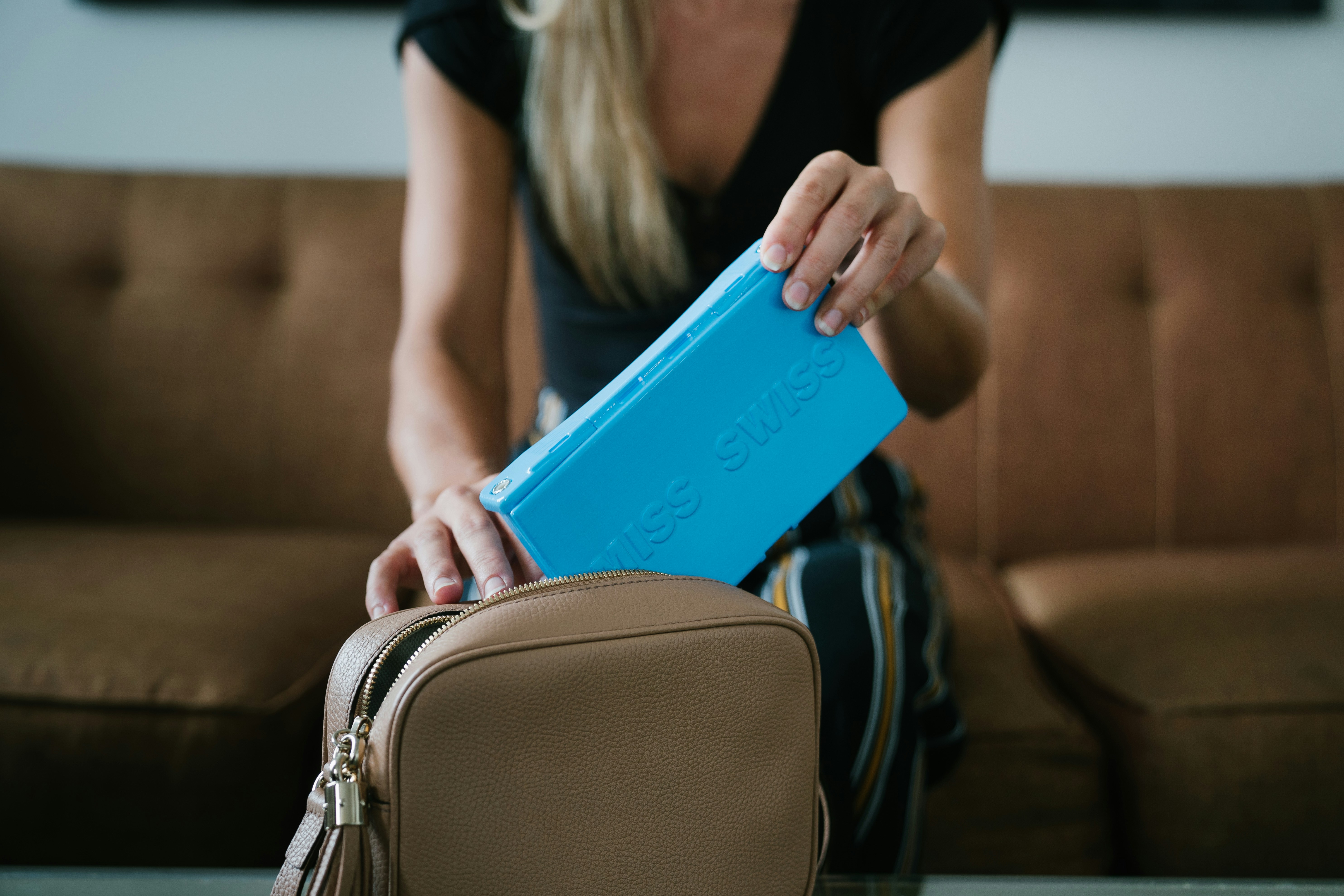 woman in black shirt holding blue tablet computer case, MISS SWISS helps makeup wearers with glamour on the go no matter where their travels take them. The MISS SWISS makeup case was created from a personal purse catastrophe. It helps you apply your makeup easily on the go, prevents your makeup from spilling, and to prevent your makeup from getting lost. It is the perfect something blue for your wedding day. Touching up your makeup after your ceremony or between photos is a breeze.