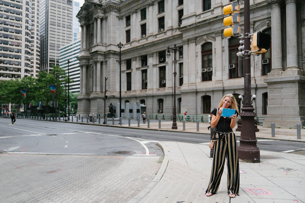 woman in black and white dress standing on pedestrian lane during daytime