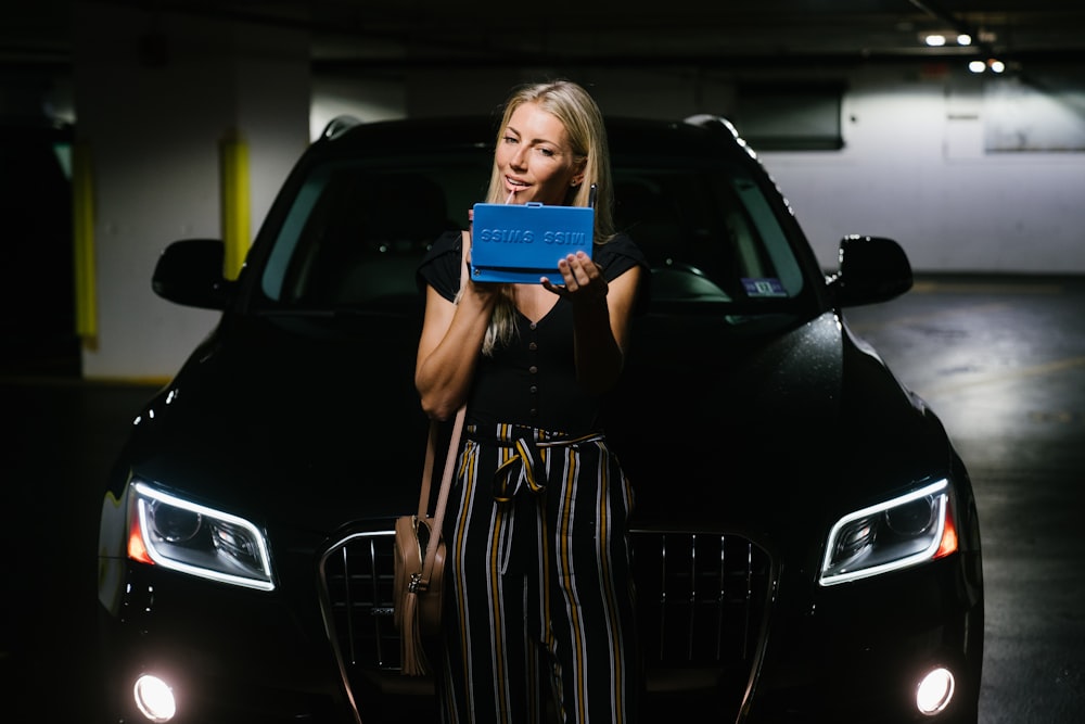 woman in black and white dress holding blue book