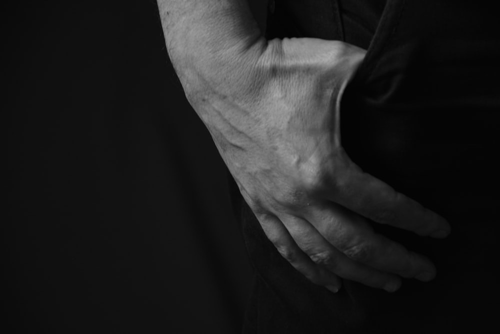 grayscale photo of person holding hands