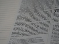 A close-up view of a page from a book, featuring columns of printed text with some words in uppercase for emphasis. The text appears neatly organized in paragraphs, and black ink is used on a white or slightly off-white paper background.