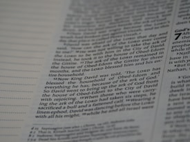 A close-up view of a page from a book, featuring columns of printed text with some words in uppercase for emphasis. The text appears neatly organized in paragraphs, and black ink is used on a white or slightly off-white paper background.