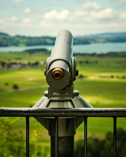 gray and black telescope on green grass field during daytime