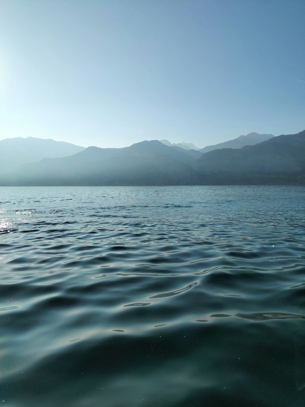 body of water near mountain during daytime